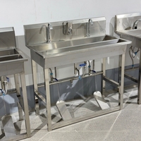 Évier industriel en acier inoxydable à double compartiment avec commande à double pédale, robinets col de cygne, cadre renforcé et pare-éclaboussures
