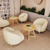 Ensemble de meubles de café, de restaurant et de salon de thé, canapé rond vert à dossier haut et table basse en bois