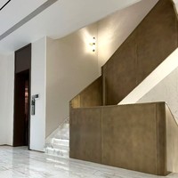 Rampe d'escalier moderne de luxe en acier courbé avec finition bronze antique et texture marbre en tons chauds pour villa intérieure