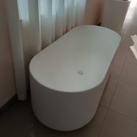 Baignoire autoportante ovale en pierre artificielle de luxe, finition mate blanche, surface solide, pour la rénovation de salle de bain moderne