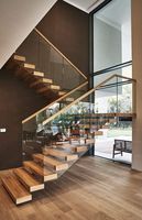 Escalier sur mesure Prima, style minimaliste, avec rampes en verre sans cadre, conçu pour les maisons à concept ouvert et les espaces de vie modernes
