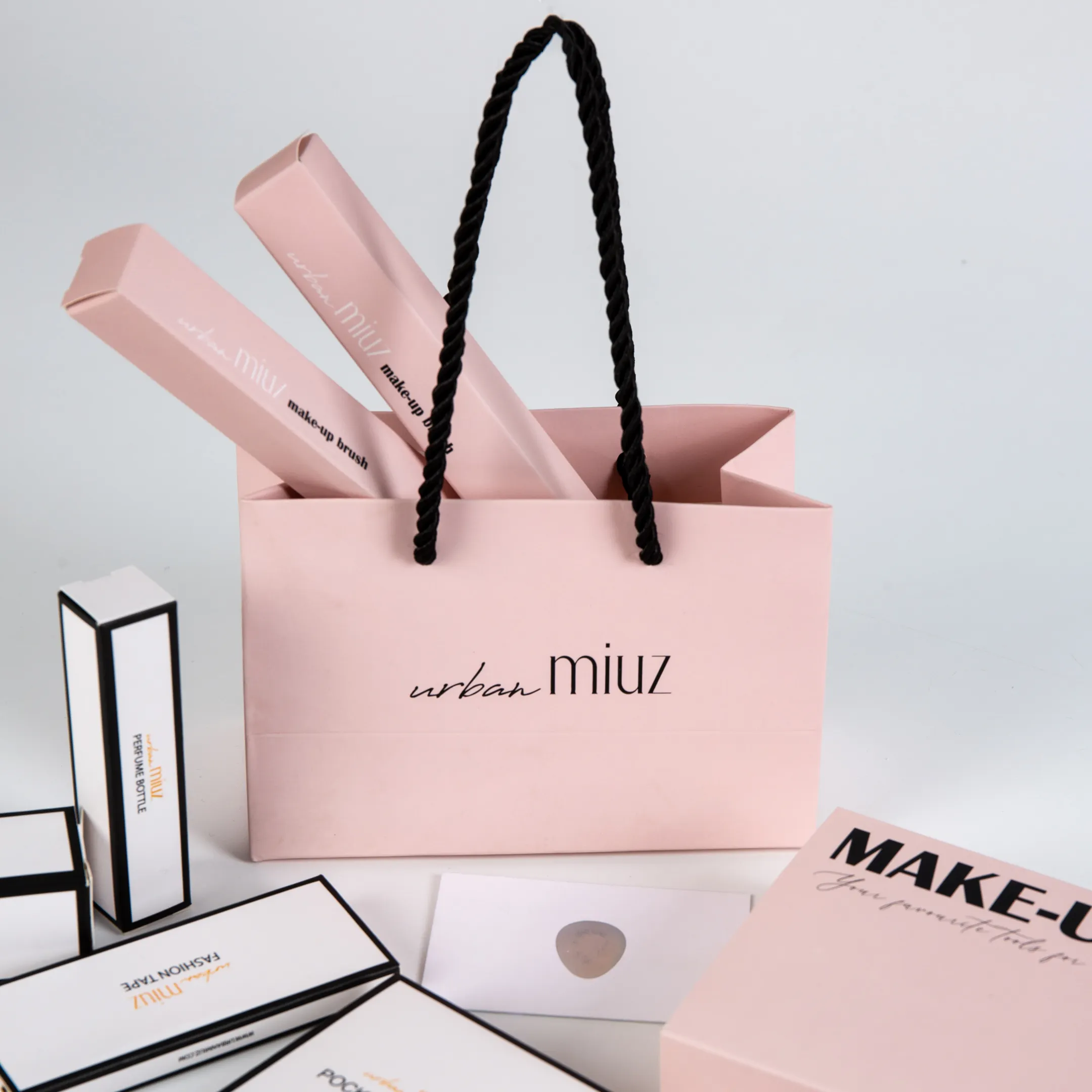 Uxury-bolsa de papel de regalo con logotipo personalizado para ropa, embalaje de boutique con asas de cinta, color rosa mate