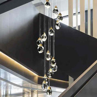 Lustre suspendu en cuivre pour escalier, avec longues pampilles en cristal et hauteur réglable, idéal pour la décoration de villas et de halls d'exposition