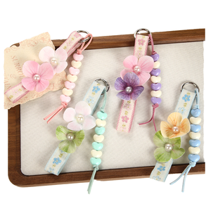 Porte-clés en plastique imitation trèfle à quatre feuilles, version coréenne 2026, style frais et tendance, avec pendentif de sac à pompon floral pour les vacances d'été - Product Image 1