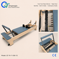Reformer de Pilates en bois d'érable bleu ardoise avec rail fixe, barre de repose-pieds intégrée et barre à ressorts réglable pour studios contemporains