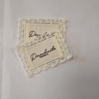 Tissu en voile de tulle avec bordure en dentelle brodée, logo en patch crème ivoire de luxe