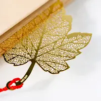 कस्टम विंटेज धातु बुकमार्क स्मारिका नक़्क़ाशी खोखले पत्तियां पीतल धातु बुकमार्क के साथ लाल लटकन
