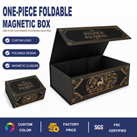 Caja Rígida Magnética Plegable con Superficie Negra Adornada con Logotipo en Lámina Dorada y Patrón Ornamentado en el Interior