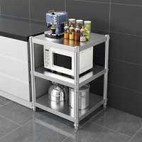 Estante de almacenamiento de cocina de acero inoxidable con tres niveles de estanterías para artículos diversos y platos.