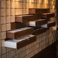 Comptoir d'accueil en blocs de noyer foncé à motifs avec tiroirs étagés, niche rétroéclairée par LED et étagère murale pour boutique de luxe