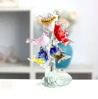 Coloridos pájaros de cristal de murano en el árbol