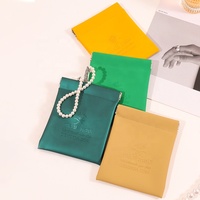 Collection de pochettes à bijoux personnalisées A1 avec logo, manches plates colorées, attaches métalliques, illustration frontale, bijoux en perles et emballage