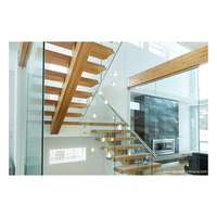 Escalier flottant sur mesure avec supports en acier, marches en chêne fumé, main courante en laiton, balustrade en corde, style nautique