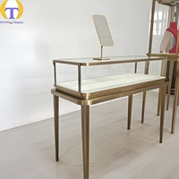Vitrine à bijoux en verre sur mesure de luxe, cadre en métal doré, éclairage LED, écologique, robuste, personnalisable pour les articles haut de gamme