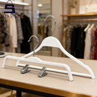 Cintres en plastique blanc à logo personnalisé, design minimaliste, robustes et peu encombrants pour magasin