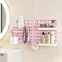 Ensemble d'organisateurs de rangement pour salle de bain en plastique rose, panneau mural sans perçage pour l'organisation des articles de toilette.