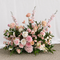 Arrangement floral au sol pour mariage, en bleu violet mélangé et rose vif, avec fleurs artificielles pour la table des mariés