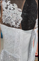 Robe de mariée sirène de luxe blanche perlée 2026 avec encolure illusion transparente, manches longues et traîne volumineuse à volants