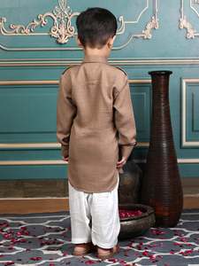 Lindo niño pequeño con una kurta beige tradicional y un shalwar blanco, posando en un elegante cuarto vintage, sonriendo, retrato con atuendo cultural. - Product Image 2