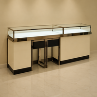 Comptoir de consultation VIP pour bijoux de luxe, îlot de présentation en verre LED avec cadre en acier inoxydable poli et deux tabourets noirs