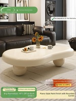 Table basse en pierre en forme de nuage, design de luxe léger d'inspiration française, ton crème, table de forme irrégulière, pour salons modernes.