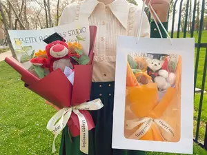 La nuova fabbrica di Bouquet di girasole di fiori artificiali di orso carino personalizza ed elabora i regali di festa della cerimonia di laurea