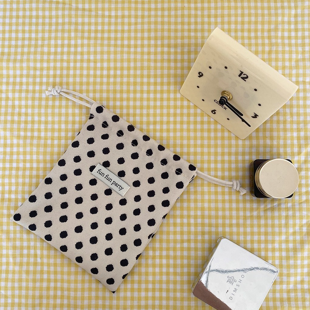 Sac à cordon en velours côtelé avec fond blanc et pois noirs.