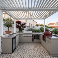 Cuisine extérieure en acier inoxydable gris en forme de U avec barbecue à gaz, évier, kamado et réfrigérateur pour pergola, personnalisable par Hyrley Cabinets