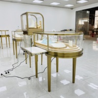 Vitrine à bijoux ovale de luxe en acier inoxydable avec éclairage LED doré, verre incurvé, couleur personnalisable, design durable pour comptoir d'îlot