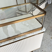Vitrine à bijoux haut de gamme en métal, présentoir à bijoux avec base en forme d'ondulation d'eau, comptoir de présentation de bijoux personnalisé en marbre
