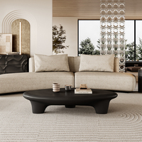 Table basse moderne noire mate, design organique irrégulier avec pieds sculpturaux épais