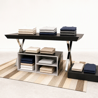Table de présentation noire avec pieds en X chromés, meuble îlot bas commercial pour vêtements