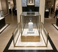 Vitrine à montres de luxe sur pied personnalisée avec éclairage LED, socle en marbre blanc premium et cadre en acier inoxydable doré