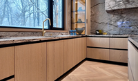 Meuble de cuisine moderne de luxe en bois clair sur mesure avec porte à panneau plat, îlot cascade en marbre et crédence pour villa