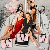 Des arcs roses décorent le sac en papier d'emballage écologique de demoiselle d'honneur de luxe au détail Portable Boutique pour le magasin de vêtements