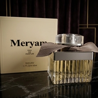 Parfum féminin en verre côtelé carré avec capuchon argenté, ruban taupe, boîte crème, senteur fleurie chaude, tenue longue durée, idéal pour les rendez-vous