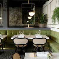 Meubles de restaurant modernes, banquette longue en velours vert, table carrée en marbre, chaise en rotin noir en métal pour café