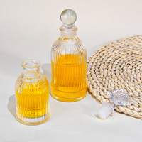 Bouteille diffuseur en verre ronde personnalisable de 100 ml, 200 ml, 500 ml avec motif vertical gravé et bâtonnets, vente en gros