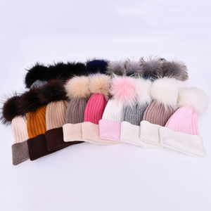 Jxwatcher OEM <span class=keywords><strong>Bonnet</strong></span> en cachemire doux tricoté avec <span class=keywords><strong>pompon</strong></span> en vraie fourrure de raton laveur, chaud, logo personnalisé, vente en gros, bonnets d'hiver bicolores pour femmes - Product Image 1