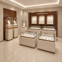 Ensemble de vitrines pour bijouterie sur mesure, comptoir en verre, piédestal et vitrines murales, motif pierre beige, métal doré, éclairage LED