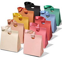 Emballage de luxe en gros en carton ivoire avec logo personnalisé imprimé en offset, matériaux recyclés, poignées torsadées pour boutiques et vente au détail