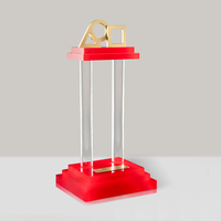 Trofeo de Acrílico Personalizado con Base Roja de Tres Niveles y Logotipos Geométricos Dorados para Regalos Corporativos