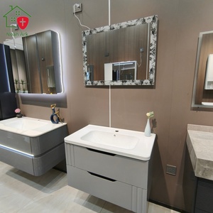 Mueble de baño gris con diseño de doble cajón, espejo con marco de encaje, encimera blanca redondeada y lavabo blanco - Product Image 5