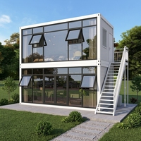 Maison préfabriquée moderne en conteneur, structure en acier modulaire avec balcon et grande fenêtre vitrée pour une vie de villégiature