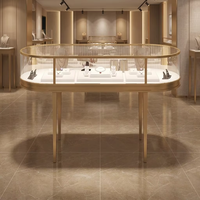 Table de présentation de bijoux ovale de luxe GZowin avec éclairage LED et supports colonnes ornés |   Dimensions personnalisables pour usage en boutique de détail
