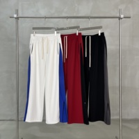 Pantalon de jogging large à rayures avec poches zippées YKK, fente à l'ourlet, panneaux contrastants et patchwork bicolore sur les côtés