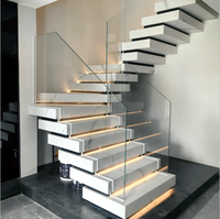 Escalier en marbre empilé lumineux avec garde-corps en verre et éclairage d'escalier chaleureux