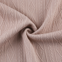 Tissu jacquard en polyester tricoté extensible, poids moyen 270 g/m², motif en forme de losange, lignes ondulées en V, 5 % élasthanne, 95 % polyester