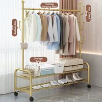 Porte-vêtements élégant et minimaliste en métal doré, robuste, sur roulettes, pour dressing