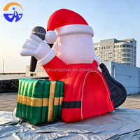 Arche gonflable géante Père Noël rockeur avec guitare, microphone et boîtes cadeaux pour l'entrée de centre commercial, la cour ou les événements de Noël
